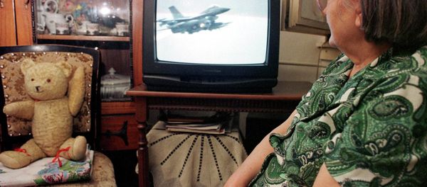 An unidentified Bosnian woman watches NATO air strikes against Yugoslav military targets on a TV screen in Tuzla, Bosnia, on Wednesday night, March 25, 1999. - Sputnik International