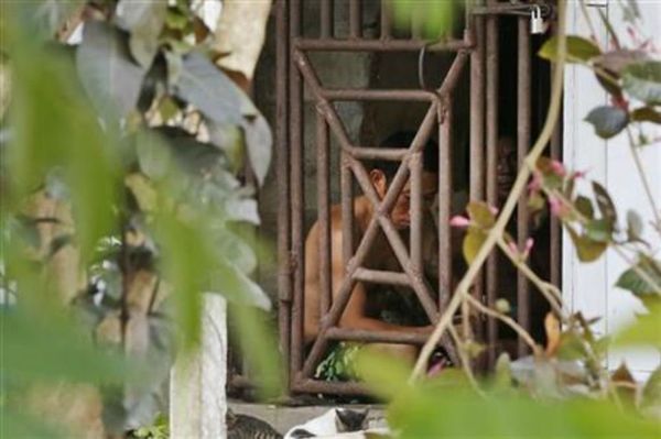 Thai and Burmese fishing boat workers sit behind bars inside a cell at the compound of a fishing company in Benjina, Indonesia. - Sputnik International