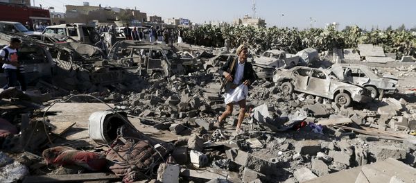 An armed man walks on the rubble of houses destroyed by an air strike near Sanaa Airport March 26, 2015. - Sputnik International
