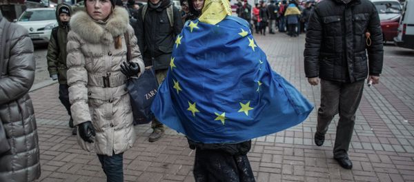 A woman is walking with the EU flag on her back A woman is walking with the EU flag on her back - Sputnik International