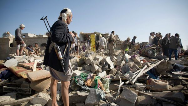 A Houthi Shiite fighter stand guard as people search for survivors under the rubble of houses destroyed by Saudi airstrikes near Sanaa Airport, Yemen A Houthi Shiite fighter stand guard as people search for survivors under the rubble of houses destroyed by Saudi airstrikes near Sanaa Airport, Yemen - Sputnik International