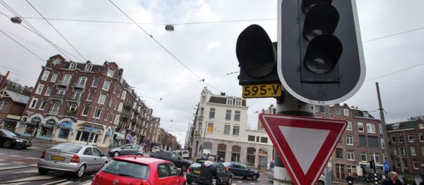Cars and bicycles improvise crossing an intersection as traffic lights are off during a power outage in Amsterdam, Netherlands, Friday, March 27, 2015 - Sputnik International