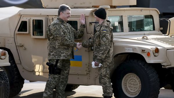 Ukraine's President Petro Poroshenko (L) welcomes a serviceman during a welcome ceremony for first plane from United State with non-lethal aid including ten Humvee vehicles to Ukraine at Borispol airport near Kiev, March 25, 2015 - Sputnik International