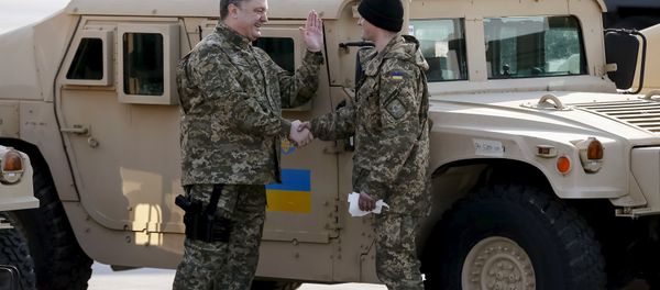 Ukraine's President Petro Poroshenko (L) welcomes a serviceman during a welcome ceremony for first plane from United State with non-lethal aid including ten Humvee vehicles to Ukraine at Borispol airport near Kiev, March 25, 2015 - Sputnik International