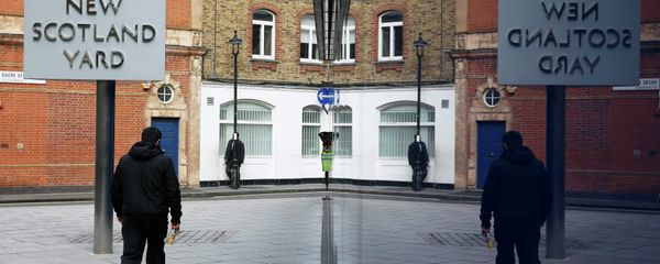A man walks past the rotating triangular sign outside New Scotland Yard in central London March 17, 2015 A man walks past the rotating triangular sign outside New Scotland Yard in central London March 17, 2015 - Sputnik International