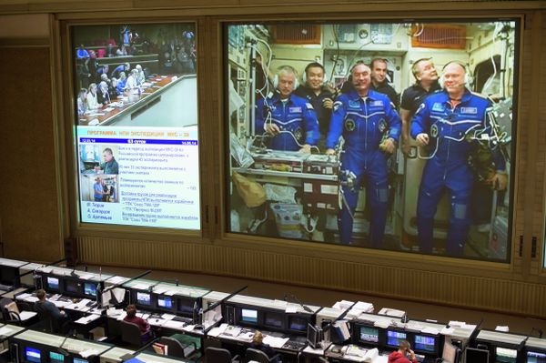 This view from Russian Mission Control Center shows live television of the Expedition 39 crew members gathered together on the International Space Station. - Sputnik International