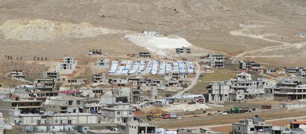 A general view shows a makeshift settlement for Syrian refugees (C, rear) on the outskirts of Arsal March - Sputnik International