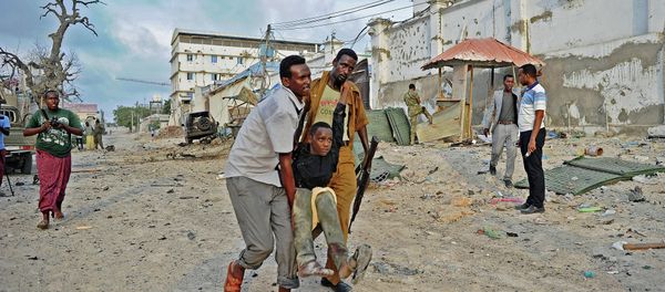 An injured youth is carried away from the scene of a car bomb attack and armed raid by Al Shebab militants on the Maka al Mukarama hotel in Mogadishu on March 27, 2015 An injured youth is carried away from the scene of a car bomb attack and armed raid by Al Shebab militants on the Maka al Mukarama hotel in Mogadishu on March 27, 2015 - Sputnik International