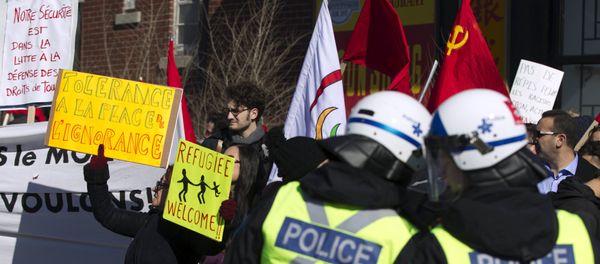 Police watch as a group of people rally to denounce a planned march by the Patriotic Europeans Against the Islamization of the West (PEGIDA) in Montreal March 28, 2015 - Sputnik International