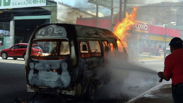 An emergency worker tries to extinguish a burning passenger van after protesters set it ablaze in the city of Chilpancingo, Mexico, Thursday, March 26, 2015 - Sputnik International