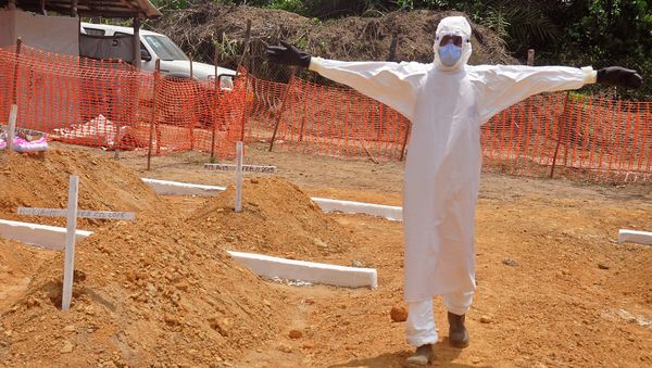 A health worker holds up his arms after he and others buried a person that they suspect died form the Ebola virus at a new graveyard on the outskirts of Monrovia, Liberia A health worker holds up his arms after he and others buried a person that they suspect died form the Ebola virus at a new graveyard on the outskirts of Monrovia, Liberia - Sputnik International