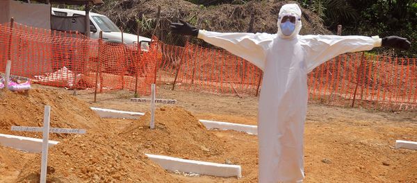 A health worker holds up his arms after he and others buried a person that they suspect died form the Ebola virus at a new graveyard on the outskirts of Monrovia, Liberia A health worker holds up his arms after he and others buried a person that they suspect died form the Ebola virus at a new graveyard on the outskirts of Monrovia, Liberia - Sputnik International