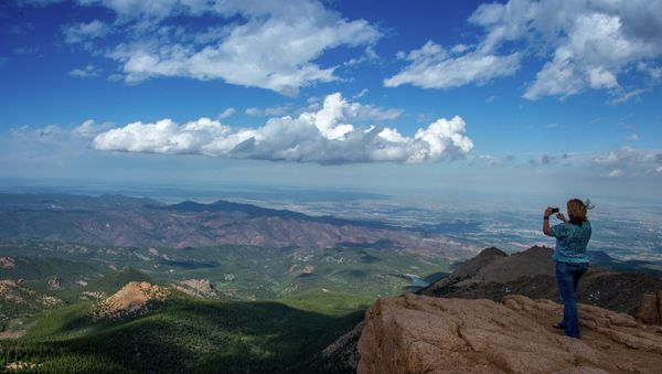 A woman takes a picture at the top of Pikes Peak mountain in the Front Range of the Rocky Mountains within Pike National Forest, 10 miles (16 km) west of Colorado Springs, Colorado, on June 08,2013 - Sputnik International