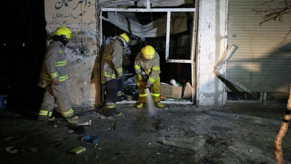 Afghan firefighters spray water at the site of a suicide attack targeting parliamentarian Gul Pacha Mujedi in Kabul, Afghanistan, Sunday, March 29, 2015 - Sputnik International