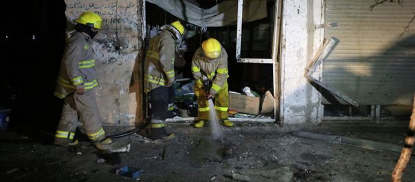 Afghan firefighters spray water at the site of a suicide attack targeting parliamentarian Gul Pacha Mujedi in Kabul, Afghanistan, Sunday, March 29, 2015 - Sputnik International