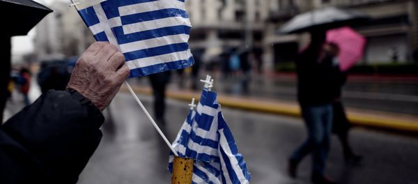 A man picks up a Greek flag placed on a street pole after a military parade in central Athens marking the Greek Independence Day on March 25, 2015 A man picks up a Greek flag placed on a street pole after a military parade in central Athens marking the Greek Independence Day on March 25, 2015 - Sputnik International