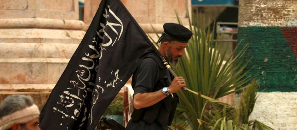 A Nusra front fighter carries his brigade's flag in Idlib city, after they took control of the area March 29, 2015 A Nusra front fighter carries his brigade's flag in Idlib city, after they took control of the area March 29, 2015 - Sputnik International