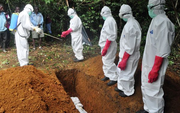 A burial team in protective gear spray each other with disinfectant after burying the body of woman suspected to have died from Ebola virus in Monrovia, Liberia - Sputnik International