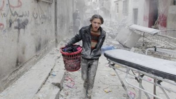 A boy carries his belongings at a site hit by what activists said was a barrel bomb dropped by forces loyal to Syria's President Bashar al-Assad in Aleppo's al-Fardous district A boy carries his belongings at a site hit by what activists said was a barrel bomb dropped by forces loyal to Syria's President Bashar al-Assad in Aleppo's al-Fardous district - Sputnik International