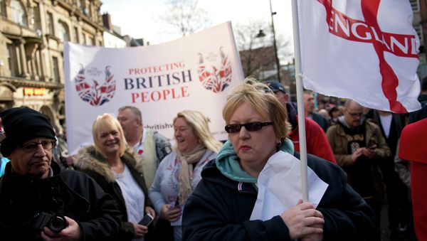 Protesters from the UK branch of the German group 'Pegida' hold a banner reading 'Protecting British People' as they demonstrate in the city centre of Newcastle upon Tyne, Northern England on February 28, 2015 - Sputnik International