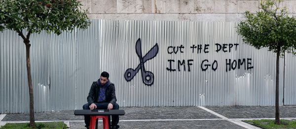 A man plays music on a digital keyboard near graffiti on a corrugated metal gate reading Cut the debt, IMF go home in Athens on February 24, 2015 A man plays music on a digital keyboard near graffiti on a corrugated metal gate reading Cut the debt, IMF go home in Athens on February 24, 2015 - Sputnik International