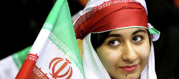 Iranian woman holds an Iranian flag during a ceremony - Sputnik International