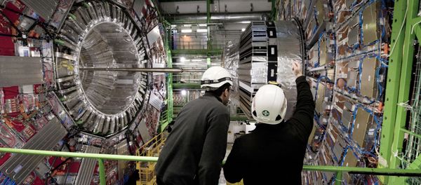 Workers gesture on February 10, 2015 in front of the CMS (Compact Muon Solenoid) Cavern at the European Organisation for Nuclear Research (CERN) in Meyrin, near Geneva - Sputnik International