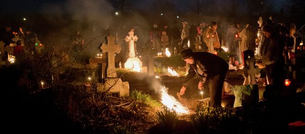 People stand by fires they lit by a relative's grave in a cemetery during an Orthodox Palm Sunday memorial for the departed in Herasti, southern Romania, early Sunday, April 5, 2015 People stand by fires they lit by a relative's grave in a cemetery during an Orthodox Palm Sunday memorial for the departed in Herasti, southern Romania, early Sunday, April 5, 2015 - Sputnik International