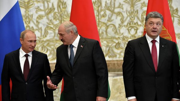 Belarus' President Alexander Lukashenko (C) gestures next to Russia's President Vladimir Putin (L) and Ukraine's President Petro Poroshenko as they meet in the Belarussian capital Minsk  - Sputnik International