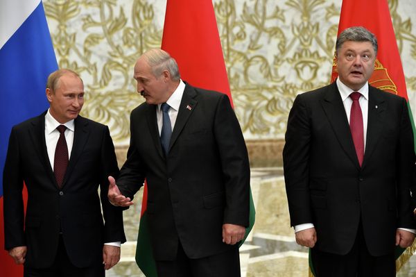Belarus' President Alexander Lukashenko (C) gestures next to Russia's President Vladimir Putin (L) and Ukraine's President Petro Poroshenko as they meet in the Belarussian capital Minsk  - Sputnik International