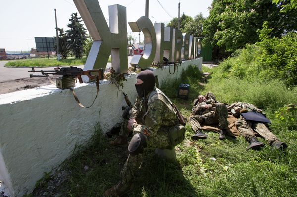 Pro-independence gunmen take their position behind a sign with the word 'Slovyansk', at a checkpoint blocking the major highway which links Kharkiv, outside Slovyansk, eastern Ukraine, Friday, May 16, 2014 Pro-independence gunmen take their position behind a sign with the word 'Slovyansk', at a checkpoint blocking the major highway which links Kharkiv, outside Slovyansk, eastern Ukraine, Friday, May 16, 2014 - Sputnik International