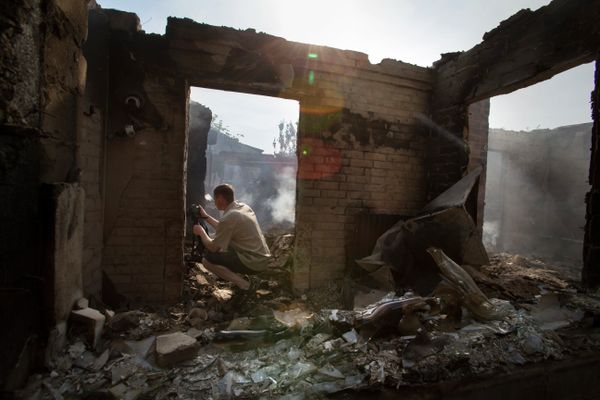 A journalist films a destroyed house following a mortar attack in Semyonovka village, outside Slavyansk, Ukraine, Friday, May 23, 2014 A journalist films a destroyed house following a mortar attack in Semyonovka village, outside Slavyansk, Ukraine, Friday, May 23, 2014 - Sputnik International