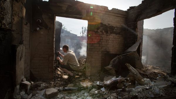 A journalist films a destroyed house following a mortar attack in Semyonovka village, outside Slavyansk, Ukraine, Friday, May 23, 2014 - Sputnik International