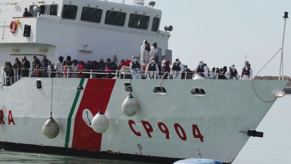 In this Wednesday, March 4, 2015, file photo, rescued migrants wait to disembark from an Italian Coast Guard vessel in Porto Empedocle, Sicily, southern Italy - Sputnik International