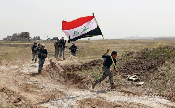 Member of the Iraqi security forces running to plant the national flag as they surround Tikrit during clashes to regain the city from Islamic State militants. Member of the Iraqi security forces running to plant the national flag as they surround Tikrit during clashes to regain the city from Islamic State militants. - Sputnik International