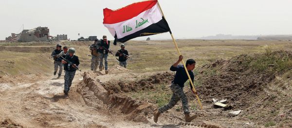 Member of the Iraqi security forces running to plant the national flag as they surround Tikrit during clashes to regain the city from Islamic State militants. - Sputnik International