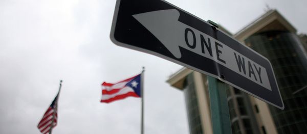 In this May 4, 2012 photo, the flags of Puerto Rico and the U.S. wave behind an English one-way traffic sign in Guaynabo, Puerto Rico, one of only a few places in Puerto Rico with street signs in English In this May 4, 2012 photo, the flags of Puerto Rico and the U.S. wave behind an English one-way traffic sign in Guaynabo, Puerto Rico, one of only a few places in Puerto Rico with street signs in English - Sputnik International
