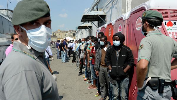 Men, part of a group of more than 330 migrants, stand in line after disembarking from the Italian Military ship Scirocco on August 30, 2014 in the port of Naples Men, part of a group of more than 330 migrants, stand in line after disembarking from the Italian Military ship Scirocco on August 30, 2014 in the port of Naples - Sputnik International