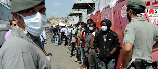 Men, part of a group of more than 330 migrants, stand in line after disembarking from the Italian Military ship Scirocco on August 30, 2014 in the port of Naples Men, part of a group of more than 330 migrants, stand in line after disembarking from the Italian Military ship Scirocco on August 30, 2014 in the port of Naples - Sputnik International