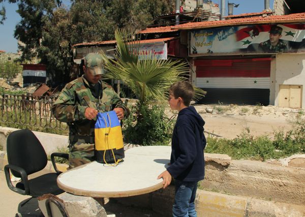 A Syrian serviceman checks documents and belongings of a refugee from the Yarmouk refugee camp on the outskirts of Damascus - Sputnik International