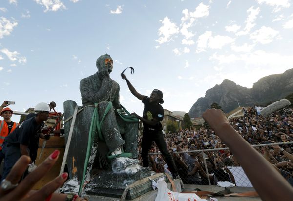 A student beats the statue of Cecil John Rhodes with a belt as it is removed from the University of Cape Town (UCT), April 9, 2015 - Sputnik International