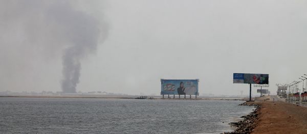 A general view shows smoke rising from the Khor Maksar neighbourhood next to the airport, in southern Yemeni city of Aden - Sputnik International