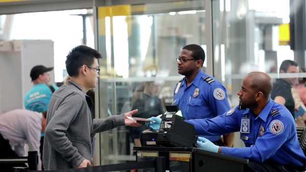 A traveler, left, hands his documents to a Transportation Security Administration officer as part of security screening at John F. Kennedy International Airport. A traveler, left, hands his documents to a Transportation Security Administration officer as part of security screening at John F. Kennedy International Airport. - Sputnik International