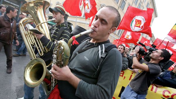 People play music as others hold Italian Communist Refoundation party flags during a demonstration in downtown Rome, Italy. (File) People play music as others hold Italian Communist Refoundation party flags during a demonstration in downtown Rome, Italy. (File) - Sputnik International