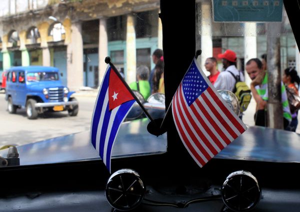 Miniature flags representing Cuba and the United States are displayed on the dash of an American classic car in Havana, Cuba. - Sputnik International