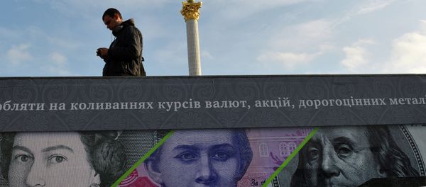 A man stands next to an advertising placard showing British pounds, US dollars and Ukrainian hryvnia banknotes in the Ukrainian capital Kiev, file photo. A man stands next to an advertising placard showing British pounds, US dollars and Ukrainian hryvnia banknotes in the Ukrainian capital Kiev, file photo. - Sputnik International