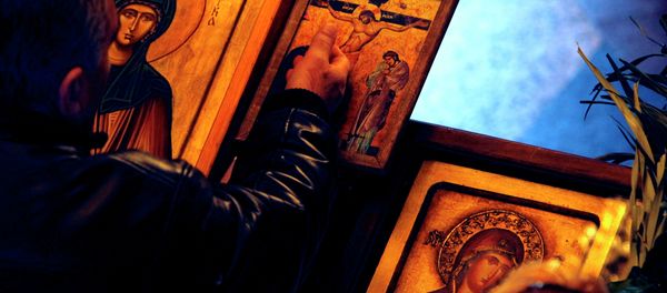 A man touches an icon with the crucifixion of Jesus Christ on Good Friday at St. Petka Orthodox church in Skopje, Macedonia - Sputnik International
