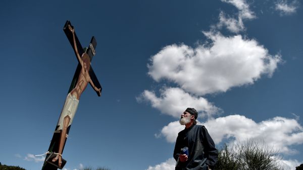 A monk of the Greek Orthodox Church looks at an image of Jesus crucified during the ceremony marking the Apokathelosis, the removal of Christ's dead body from the Cross, which forms a key part of Orthodox Easter, in a ceremony at the Church of the Dormition of the Virgin in Penteli, north Athens - Sputnik International