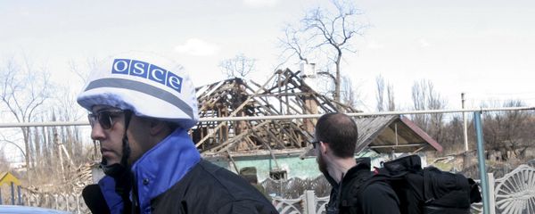 Members of the Special Monitoring Mission of the Organization for Security and Cooperation (OSCE) to Ukraine walk past a house damaged by shelling, in the village of Spartak outside Donetsk April 10, 2015 Members of the Special Monitoring Mission of the Organization for Security and Cooperation (OSCE) to Ukraine walk past a house damaged by shelling, in the village of Spartak outside Donetsk April 10, 2015 - Sputnik International