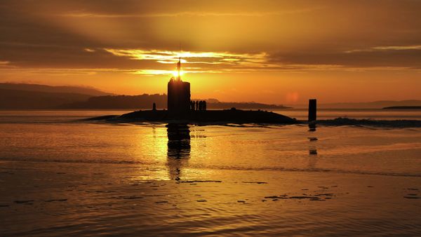 In this image made available by the Ministry of Defence in London, Monday Oct. 18, 2010, the sun rises over the Royal Navy nuclear attack submarine HMS Triumph, as she comes into a naval base on the River Clyde in Scotland, early Sunday Oct. 17, 2010 - Sputnik International